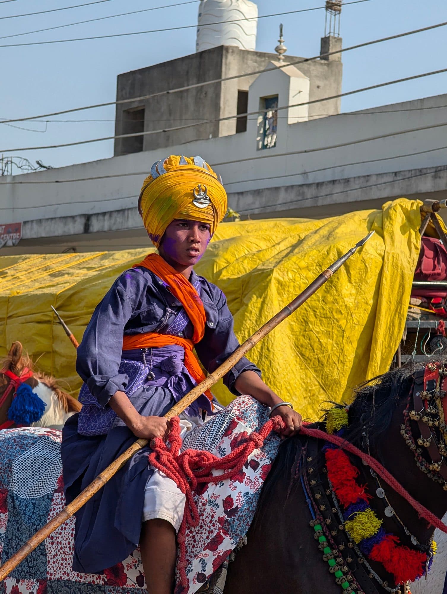 A Nihang Sikh warrior in blue and saffron holding a spear